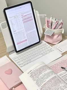 an open laptop computer sitting on top of a desk next to a notebook and pen