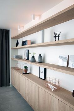 a living room with shelves and pictures on the wall