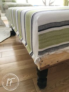 a wooden bench with a striped blanket on it