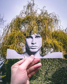 a person holding up a piece of paper with the image of a woman's face on it