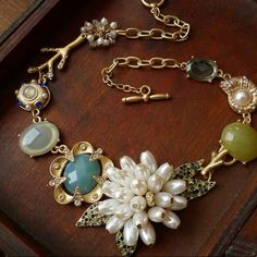 a close up of a bracelet on a table with beads and charms attached to it