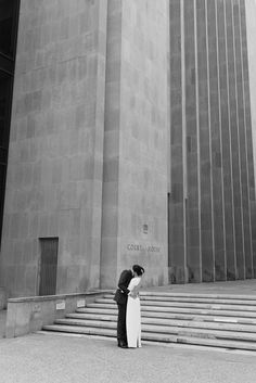 a man and woman standing in front of a building