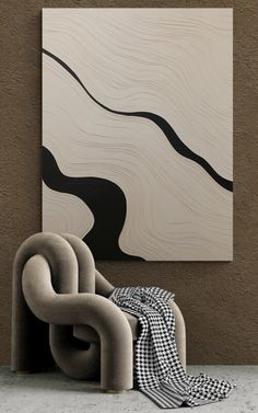 an abstract painting hangs on the wall next to a modern chair and rug in front of it