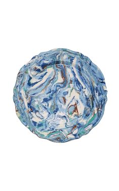 a blue and white marbled bowl sitting on top of a white table next to a wall