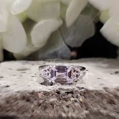 an engagement ring sitting on top of a piece of wood