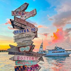 a wooden sign sitting on the side of a boat in front of a body of water