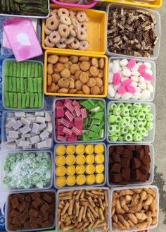 several trays filled with different types of food and snacks in plastic containers on top of a table