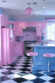 a kitchen with pink appliances and checkered flooring on the floor is seen in this image