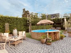 a backyard with a pool and patio furniture