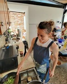 a woman is cooking food in the kitchen