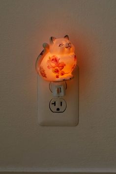 a light that is on the wall with a cat lamp in it's side