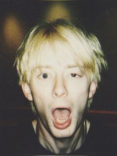 a young man with blonde hair making a surprised face