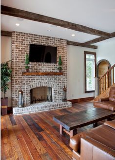 a living room filled with furniture and a flat screen tv mounted above a fire place