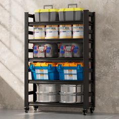 a shelf with several buckets and containers on it in front of a concrete wall