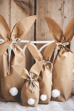 three brown paper bags with cotton balls tied to the top and two are sitting next to each other