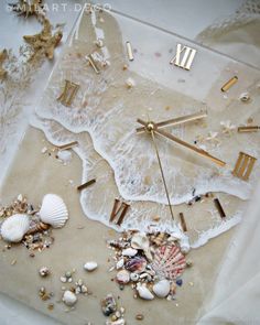 a clock that is on top of a table with shells and seaweed around it