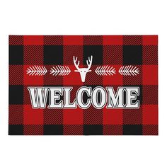 a welcome mat with a deer head and arrow on the front, in red and black plaid