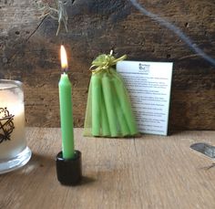 a lit candle next to a book on a table