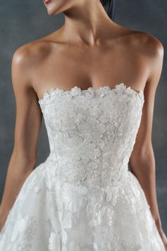 a woman in a white wedding dress is posing for the camera with her hand on her hip