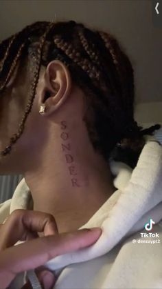 a woman with braids on her head has a message tattooed on her neck