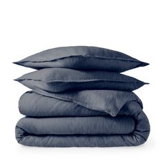 three pillows stacked on top of each other in front of a white background with blue linens