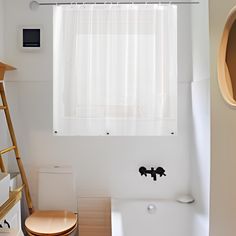 a bathroom with a toilet, sink and bathtub next to a window in the wall