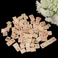 wooden scrabbles with letters spelling out the word love on them next to a bouquet of flowers