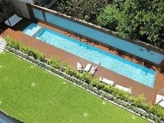 an aerial view of a swimming pool in a backyard with grass and trees around it