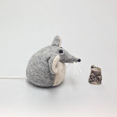 a small toy mouse next to a tiny bell