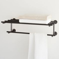 two black towel racks with white towels hanging on them