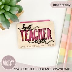 a wooden stamp with the words best teacher on it next to a potted plant