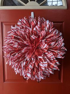 a red and white wreath hanging on the front door