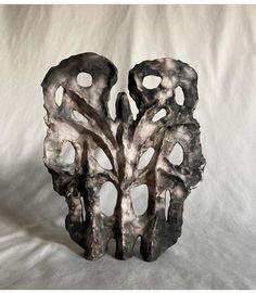 a sculpture made out of metal on a white background with the image of a tree in it's center