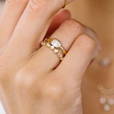 a close up of a person's hand with a ring on their finger and an engagement band