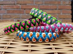 several different colored bracelets sitting on top of a wicker table next to a brick wall