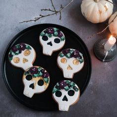 three decorated sugar skulls on a black plate