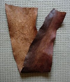 a piece of leather sitting on top of a white table next to another piece of wood