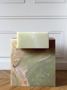 a soap bar sitting on top of a wooden floor next to a white paneled wall