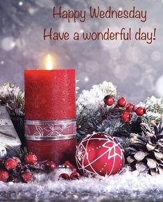 a red candle sitting on top of a pile of snow covered ground next to christmas decorations