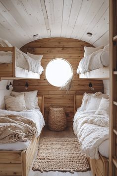 the inside of a small cabin with three beds and a round window in the wall