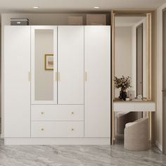 a white closet with gold handles and drawers next to a mirror on the wall in an empty room