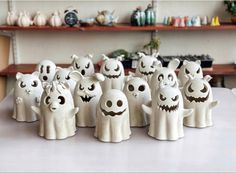 a group of halloween ghost figurines sitting on top of a table