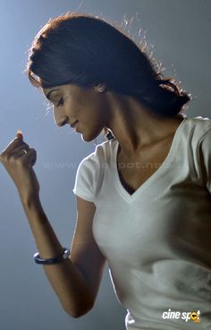 a woman in white shirt holding her hand up