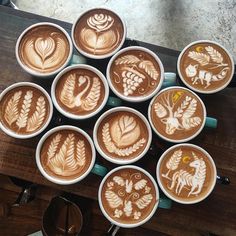 there are many cups that have different designs on them in the shape of animals and leaves