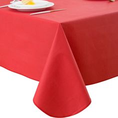 a red table cloth with white plates and utensils on it, ready to be served