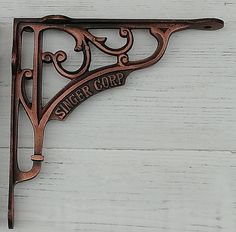 a metal shelf bracket on a white wooden wall with the words laugh corp hanging from it's side