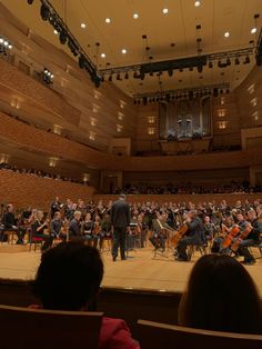 an orchestra performing on stage with people watching