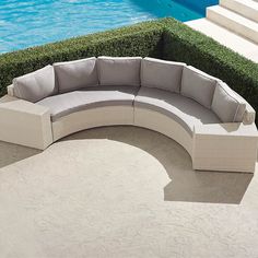 a curved couch sitting next to a swimming pool