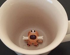 a coffee cup with a toy dog in it