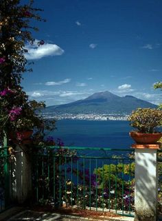 a balcony with a view of the ocean and volcano